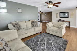 Living room featuring hardwood / wood-style floors, a textured ceiling, and ceiling fan