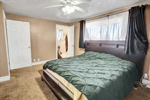 Bedroom featuring a textured ceiling, carpet floors, and ceiling fan