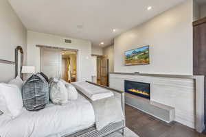 Bedroom featuring a barn door and dark wood-type flooring