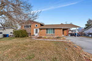 View of front of home featuring a carport and a front yard