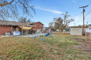 View of yard featuring a shed and a playground