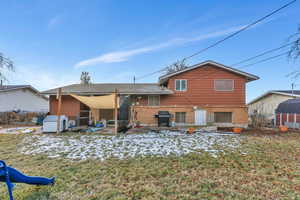 Back of property with a lawn and a patio