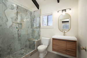 Bathroom featuring tile patterned floors, vanity, toilet, and a shower with shower door