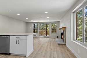 Kitchen with plenty of natural light, white cabinets, and light wood-type flooring