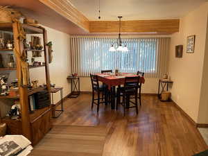 Dining area with dark hardwood / wood-style floors and a notable chandelier