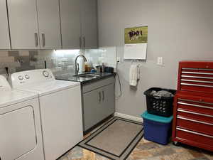 Laundry room featuring custom cabinets, separate washer and dryer, and sink