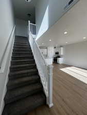 Stairs featuring hardwood / wood-style flooring