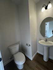 Bathroom with wood-type flooring, toilet, and sink