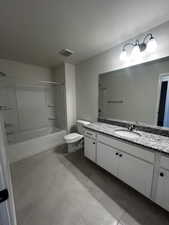 Full bathroom featuring shower / bathing tub combination, vanity, tile patterned flooring, toilet, and a textured ceiling