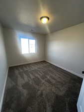 Carpeted spare room with a textured ceiling