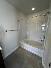 Bathroom with tile patterned flooring, vanity, and tiled shower / bath combo