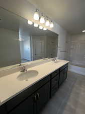 Bathroom with tile patterned flooring, vanity, and shower / tub combination