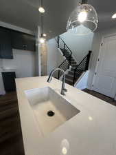 Kitchen with sink, dark wood-type flooring, and decorative light fixtures