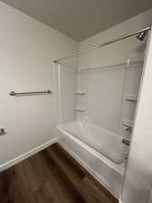 Bathroom featuring bathtub / shower combination and hardwood / wood-style flooring