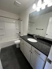 Full bathroom featuring vanity, tile patterned flooring, toilet, a textured ceiling, and tub / shower combination