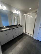 Bathroom featuring tile patterned floors, vanity, a textured ceiling, and walk in shower