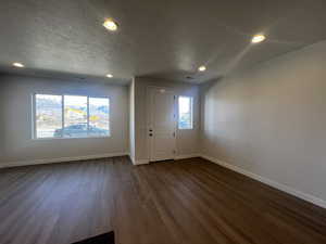 Foyer with dark hardwood / wood-style flooring and a textured ceiling