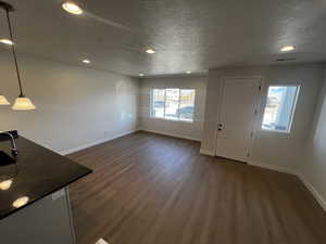 Foyer entrance featuring a textured ceiling and dark wood-type flooring