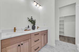 Primary bathroom featuring vanity and walk in closet