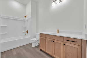 Full bathroom featuring vanity, hardwood / wood-style floors, toilet, and shower / bath combination