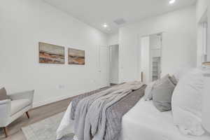 Bedroom with hardwood / wood-style flooring and a spacious closet