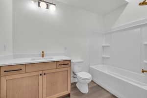 Full bathroom featuring shower / tub combination, vanity, toilet, and hardwood / wood-style floors