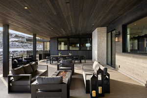 Snow covered patio with a mountain view and an outdoor living space with a fire pit