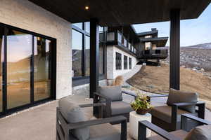 Patio terrace at dusk featuring a mountain view, a balcony, and an outdoor hangout area