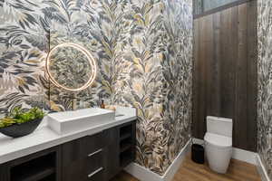 Bathroom with hardwood / wood-style flooring, vanity, and toilet