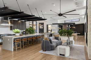 Living room featuring ceiling fan, sink, and light wood-type flooring