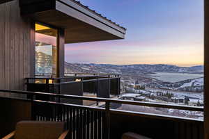 Snow covered back of property with a mountain view