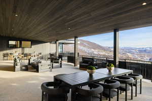 Carpeted dining room featuring a mountain view, wood walls, and wood ceiling