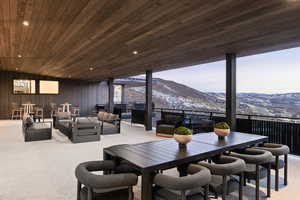 Dining space featuring a mountain view, carpet flooring, wooden ceiling, and wood walls