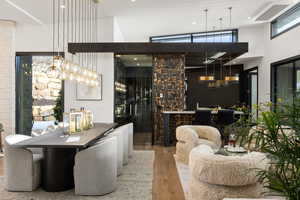 Wine cellar with hardwood / wood-style floors and high vaulted ceiling