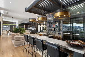 Bar featuring a mountain view, light hardwood / wood-style floors, sink, and stone counters