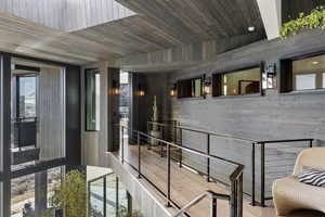 Corridor featuring hardwood / wood-style floors, wood walls, and wooden ceiling