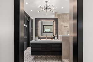 Bathroom with a chandelier and vanity