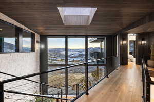 Corridor featuring a skylight, a mountain view, wood ceiling, and hardwood / wood-style flooring