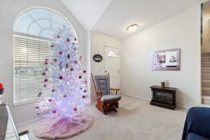 Interior space with lofted ceiling and light carpet