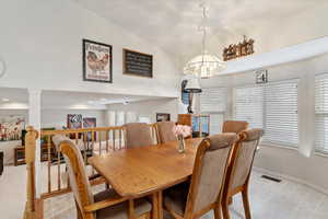 Dining area with vaulted ceiling and a chandelier