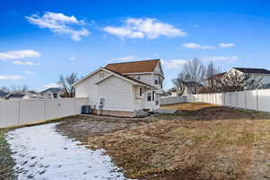 Snow covered rear of property with central air condition unit