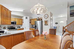 Tiled dining space with vaulted ceiling and a notable chandelier