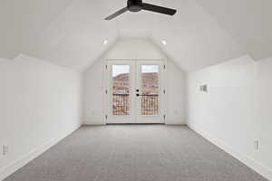 Bonus room with ceiling fan, french doors, light colored carpet, and vaulted ceiling