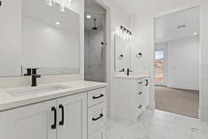 Bathroom featuring a tile shower and vanity