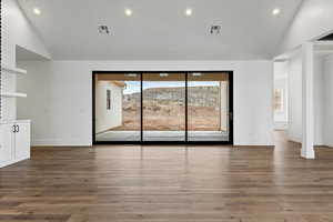 Unfurnished living room with high vaulted ceiling and dark wood-type flooring