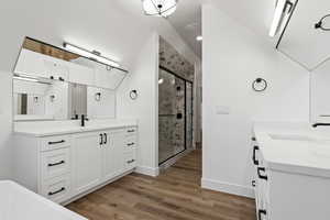 Bathroom with vanity, an enclosed shower, and hardwood / wood-style flooring