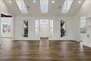 Entrance foyer with high vaulted ceiling and dark hardwood / wood-style floors