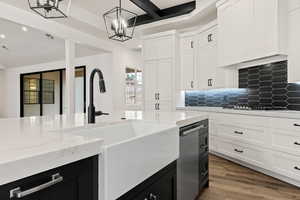 Kitchen with pendant lighting, hardwood / wood-style flooring, white cabinetry, and gas stovetop