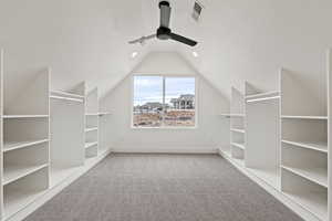 Spacious closet featuring carpet, ceiling fan, and lofted ceiling