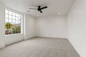 Carpeted spare room with ceiling fan